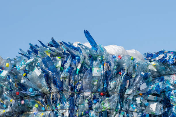 Used plastic trash. Pressed beverage packagings on a blue sky background Recyclable PET bottles with colored caps baled for garbage collection to processing plant. Waste sorting, recycling or disposal polyethylene terephthalate stock pictures, royalty-free photos & images