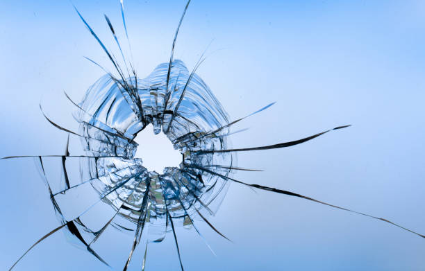 istock Cracks in the window glass on a background of sky. 1319854818