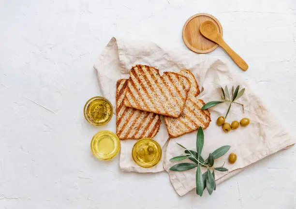 Flat lay Organic olive with green olives, herbs, spices and ciabatta bread on white background.  healthy food concept."n"n