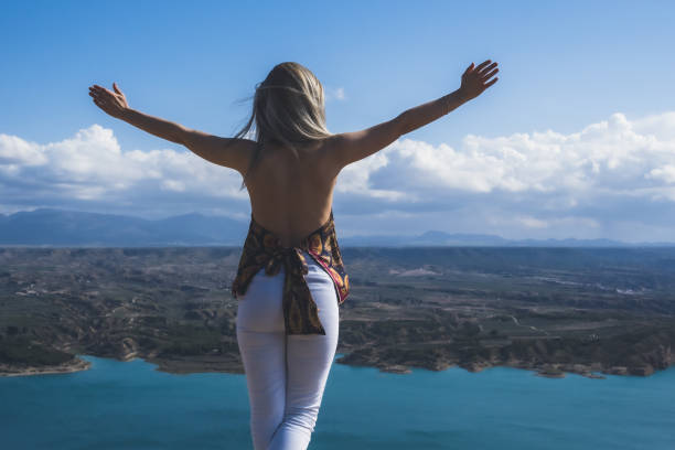 istock Girl with spread arms in a landscape 1319857328