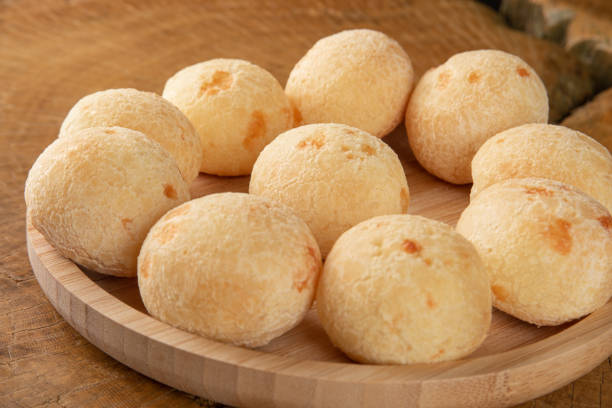 istock Brazilian Cheese bread, cheese breads arranged on wooden plate, on rustic wood, selective focus. 1319857450