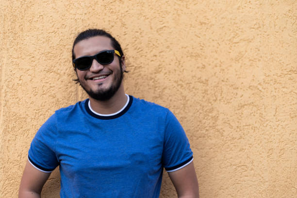 istock young latino man with sunglasses smiling looking at camera. Horizontal shot 1319862369