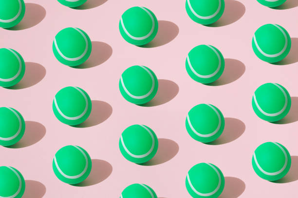istock Arranged green tennis ball on a pink background. Minimum pattern. 1319865160