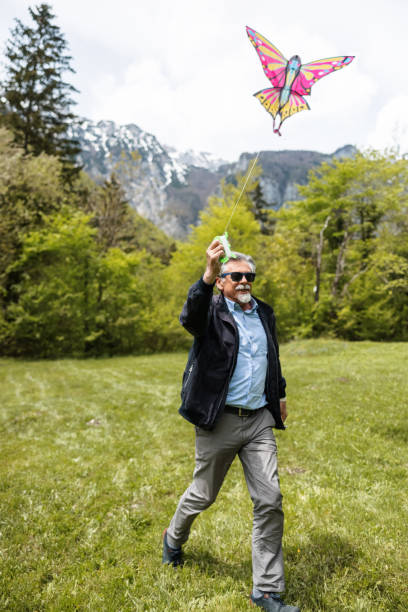 istock Senior Man Flying A Kite Outdoors 1319866844