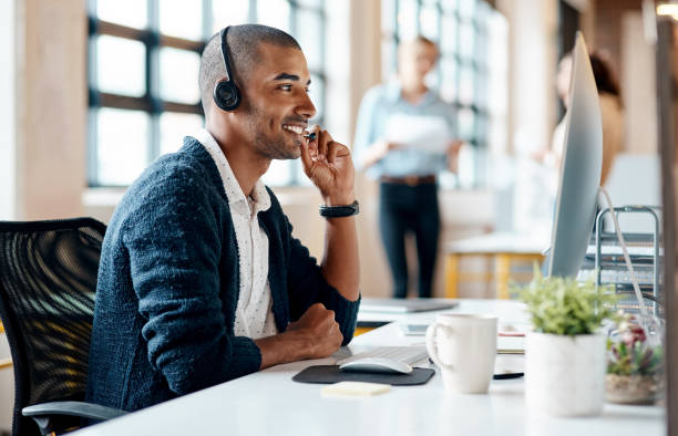 istock Shot of a young businessman wearing a headset while working on a computer in an office 1319873299