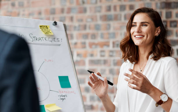 Shot of a young businesswoman presenting notes on a whiteboard in an office stock photo