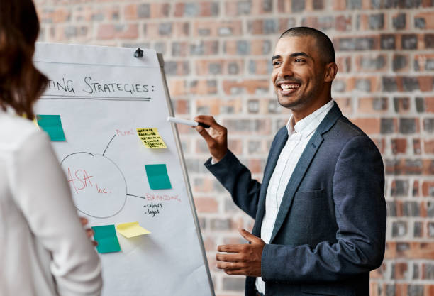 istock Shot of a young businessman presenting notes on a whiteboard in an office 1319874304