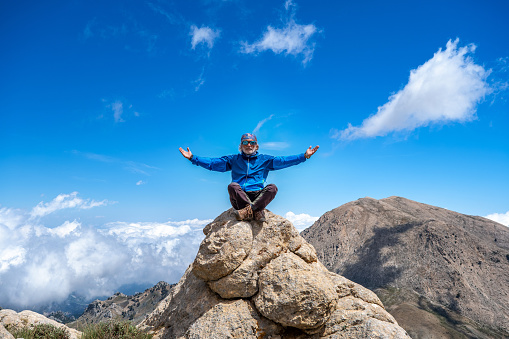 60 year old man enjoying nature in awe at high altitude. With bandanna, sunglasses