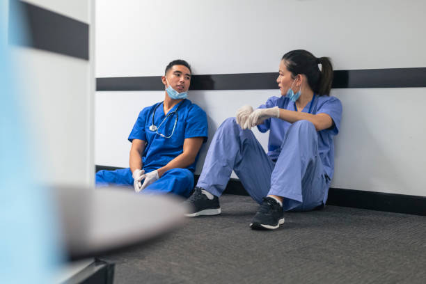 two nurses comfort each other during covid-19 pandemic - nurse hygiene emotional stress surgeon imagens e fotografias de stock