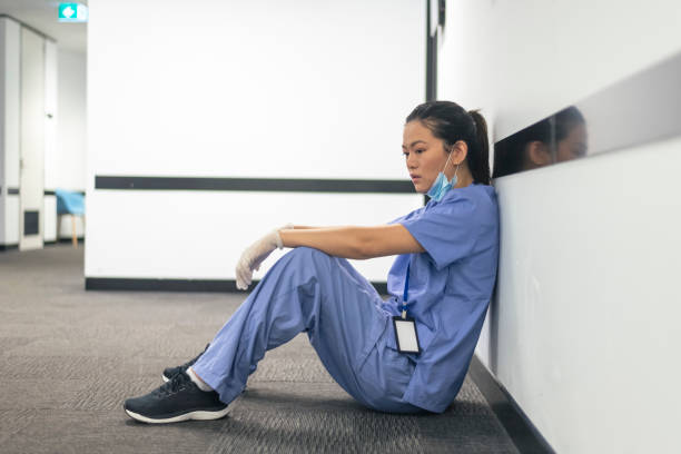 enfermera sobrecargada de trabajo se toma un descanso durante la pandemia - doctor tired protective workwear sadness fotografías e imágenes de stock