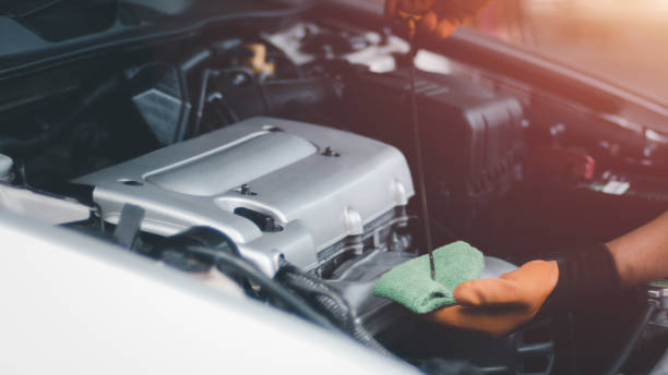 istock Auto mechanic working in garage. Repair service.Check engine oil level. 1319881693