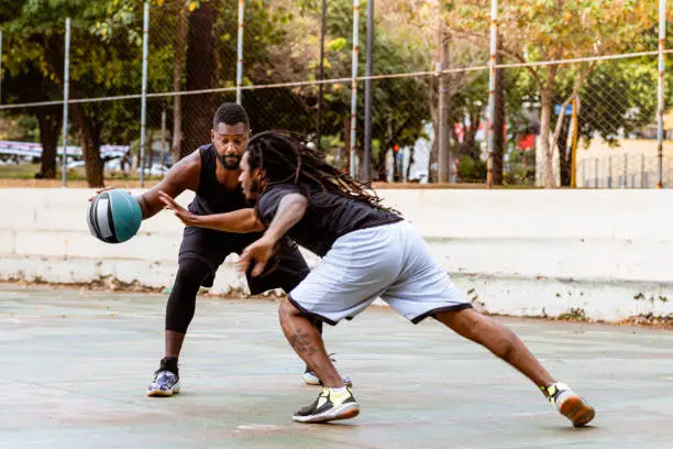 Photo of Player reaching in to steal ball from opponent