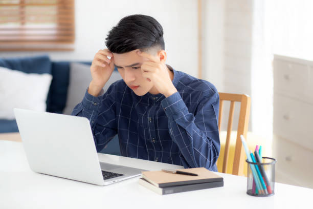 istock Young asian business man headache during working on laptop computer with deadline on desk at home, businessman with failure exhausted and tired, stress and worried, frustrated and unsuccessful. 1319887151