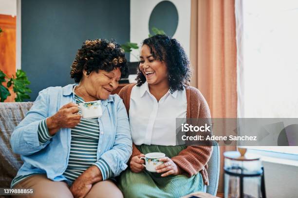 Shot Of A Young Woman Having Coffee With Her Elderly Relative On The Sofa At Home Stock Photo - Download Image Now