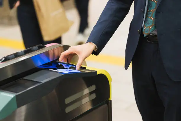 Businessmen passing through ticket gates with touchless technology (hands, ups, body parts)