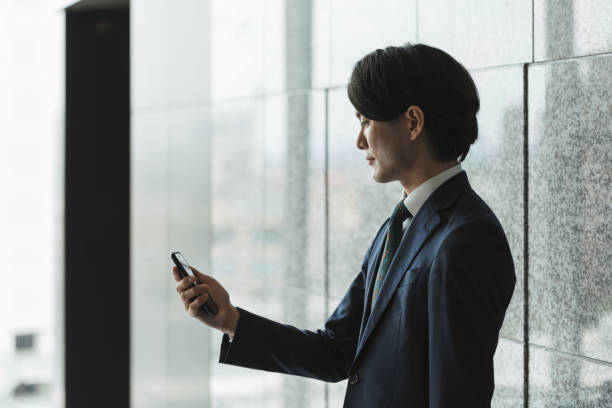 istock Image of young man with smartphone, IoT and business (backlight, profile, silhouette) 1319889745