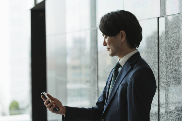 istock Image of young man with smartphone, IoT and business (backlight, profile, silhouette) 1319889757