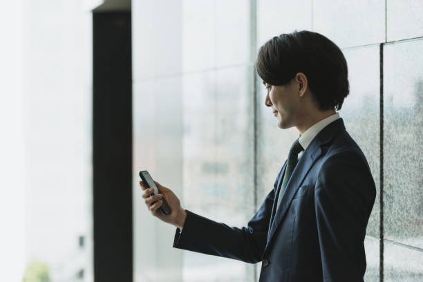 istock Image of young man with smartphone, IoT and business (backlight, profile, silhouette) 1319889759