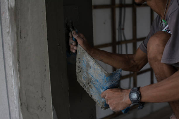 istock Plasterer Cconcrete worker at wall of house construction 1319893592