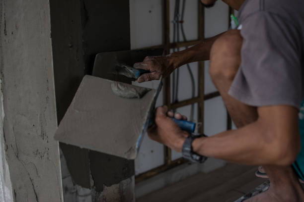 istock Plasterer Cconcrete worker at wall of house construction 1319893605