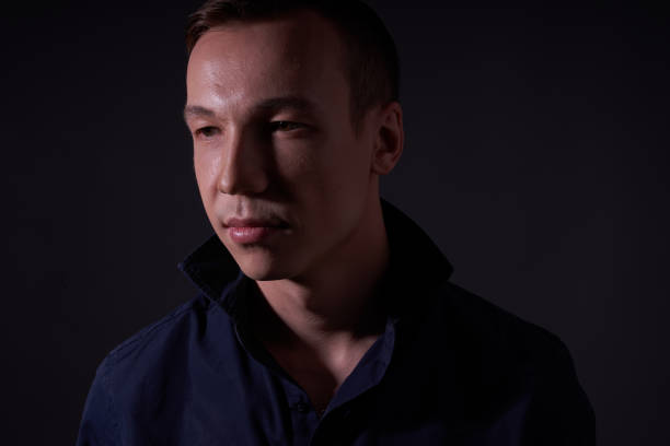 istock Beautiful young guy on a black background in the Studio 1319898595