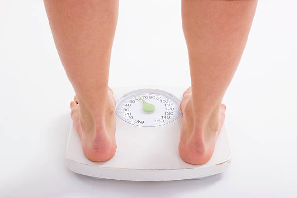 istock Woman standing on weight scale 131989933