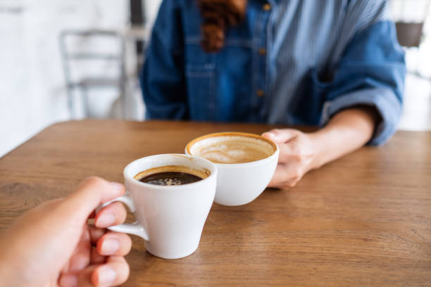 istock a woman and a man clinking coffee cups together in cafe 1319906477