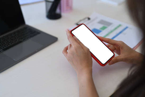 istock View over businesswoman shoulder using mobile phone in office. 1319910931