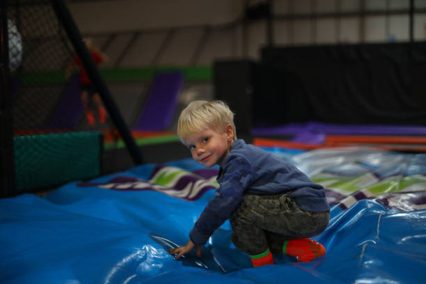 istock A young boy is jumping in a indoor trampoline play area. 1319912758