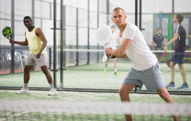 istock Focused padel player hitting two handed backhand in close court 1319912848