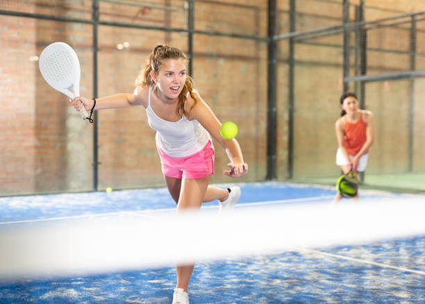 istock Expressive resolved girl playing paddle ball on closed court 1319914160