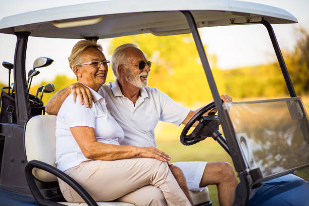 istock Elderly golf couple rides in a golf cart. 1319915245
