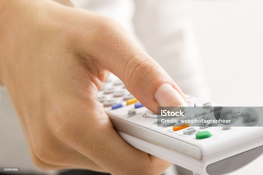 Mujer agarrando control remoto - Foto de stock de 2000-2009 libre de derechos