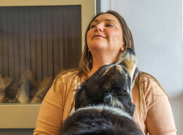 istock Attractive middle-aged woman cuddling dog 1319919476