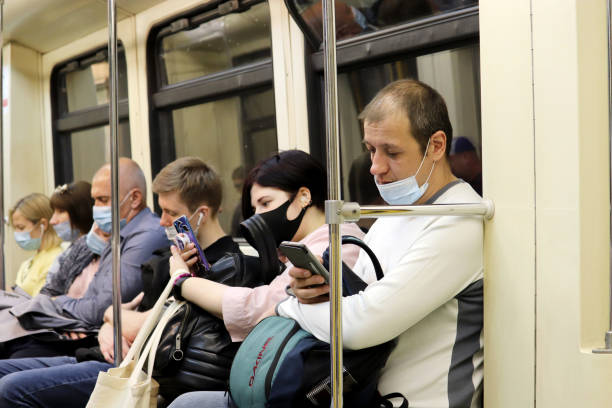 folla di persone in treno in metro, passeggeri in maschera durante epidemia coronavirus - bus transportation indoors people foto e immagini stock