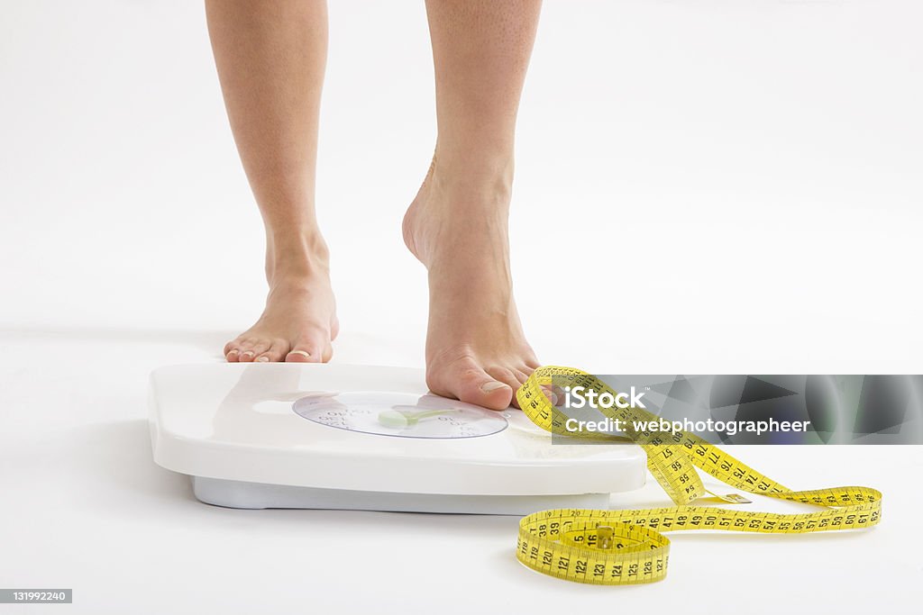 Diet Woman stepping on scale, canon 1Ds mark III Weight Scale Stock Photo