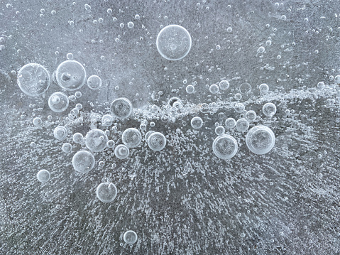 air bubbles frozen into ice in winter