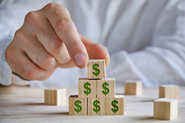 istock Men placing wooden blocks with dollar signs, growth concept 1319926053