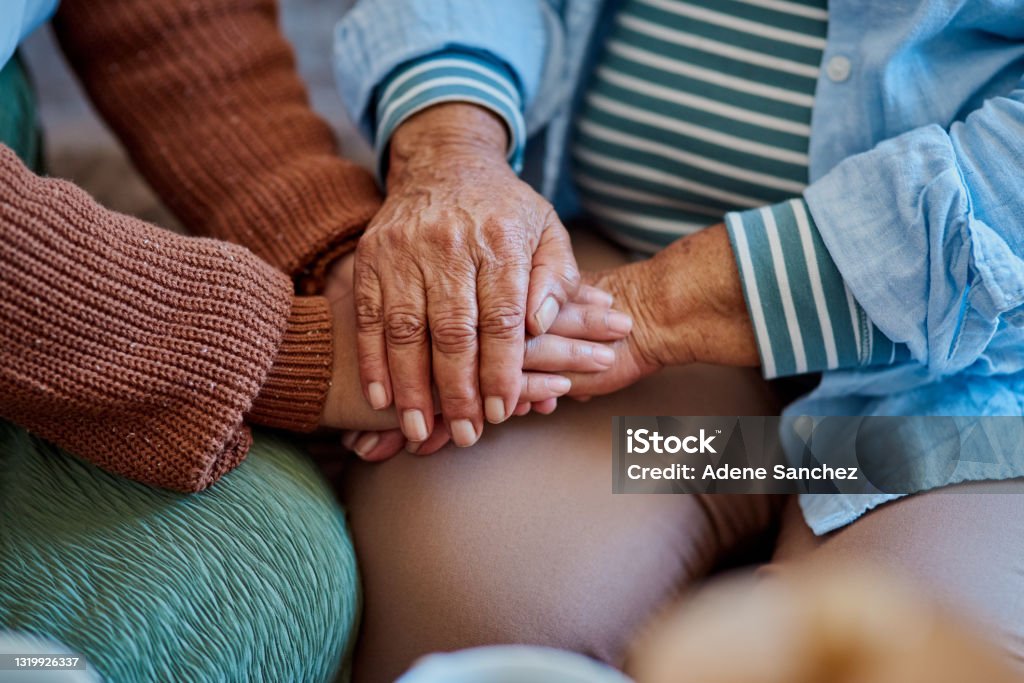 Shot of an unrecognisable woman holding hands with her elderly relative on the sofa at home Thank you for never leaving my side Senior Adult Stock Photo