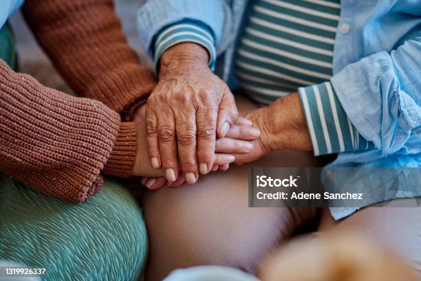 Shot Of An Unrecognisable Woman Holding Hands With Her Elderly Relative On The Sofa At Home Stock Photo - Download Image Now
