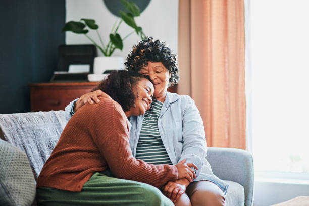 strzał starszej kobiety relaksującej się z córką na kanapie w domu - senior adult senior couple happiness couple zdjęcia i obrazy z banku zdjęć