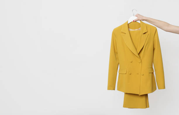 blazer amarillo de doble pecho colgando sobre un coathanger aislado sobre fondo blanco. moda de mujer moderna de primera calidad hecha a mano. - tailor suit textile fashion fotografías e imágenes de stock