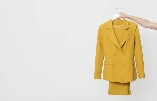 blazer jaune à double poitrine accroché à un porte-manteau isolé sur fond blanc. mode féminine moderne de qualité supérieure faite à la main. - blazer photos et images de collection