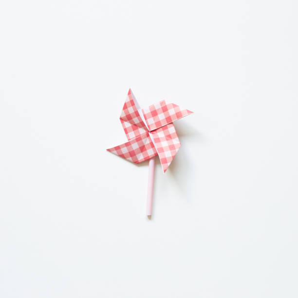 istock Red check pattern paper pinwheel isolated on white background. top view 1319928291