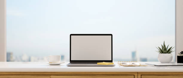 istock Laptop with mock-up screen on the desk with panoramic window in the background, 3D rendering 1319929646