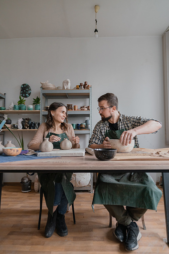 Young Caucasian man and woman ceramist working together in their studio