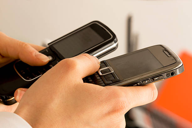 istock Woman witgh two cellphones 131993121
