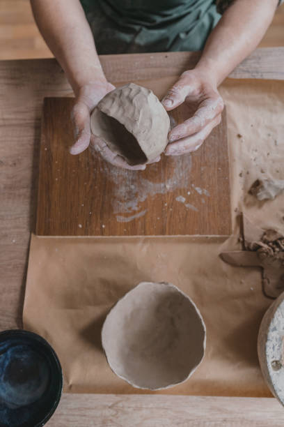 istock Male ceramist working in her studio, close up, high angle view 1319931246
