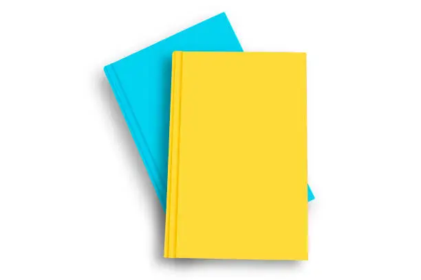 Photo of Colored blank books on top of each other over white background.