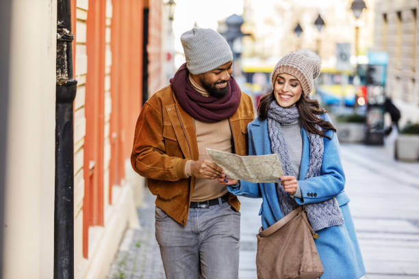 istock Young Multi-Ethnic Couple is Walking in the City and Exploring the Sights Using a Tourist Map. 1319933031
